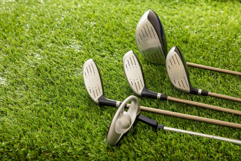 Golf Clubs On Green Grass Golf Course Close Up View .jpg